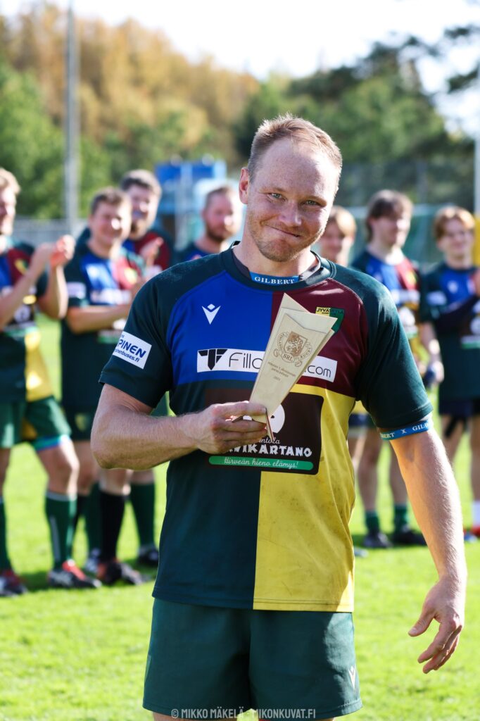 Jyväskylä Rugby Clubin miesten joukkueen kapteeni Tapio Lahtinen poseeraa 1. divisioonan kauden parhaan pelaajan palkinnon kanssa.